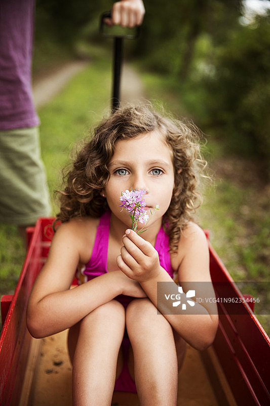 坐在手推车里的女孩捧着花的肖像图片素材
