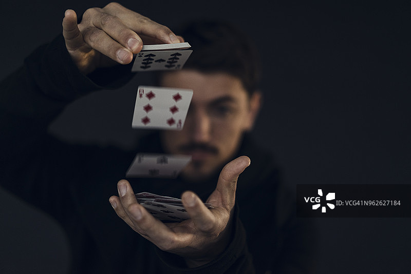 魔术师用扑克牌变戏法，特写图片素材