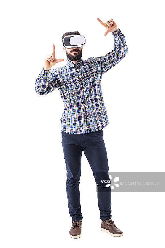 年轻的蓄着胡须的成年商人戴着虚拟现实眼镜，用放大或调整屏幕手势图片素材