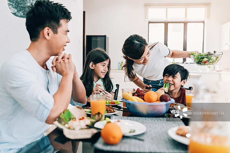 幸福的亚裔家庭在餐桌上图片素材