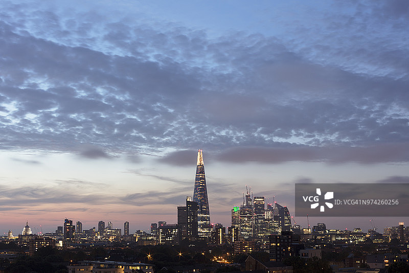 在引人注目的天空映衬下，照亮了伦敦城市的天际线图片素材