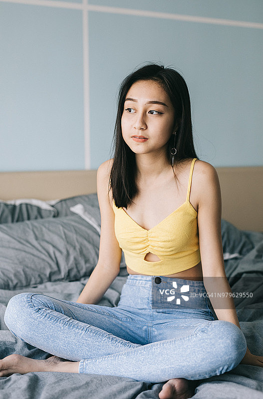 年轻女子坐在床上图片素材