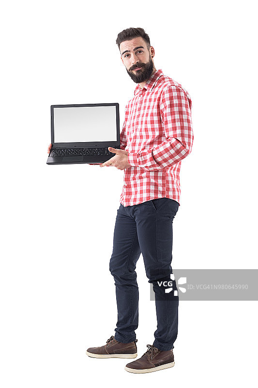 酷酷的胡子嬉皮士在智能休闲衣服显示空白笔记本显示器。图片素材