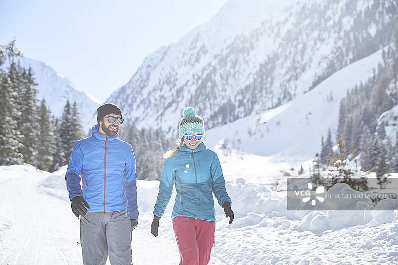 一对情侣在白雪覆盖的风景中散步图片素材