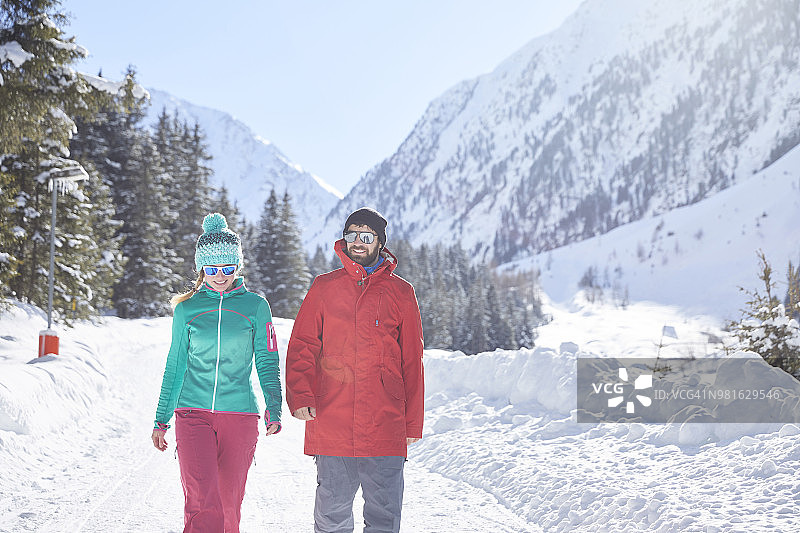 一对情侣在白雪覆盖的风景中散步图片素材