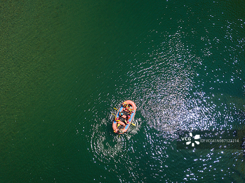 鸟瞰图一群男人和女人在一条平静的河里漂流图片素材