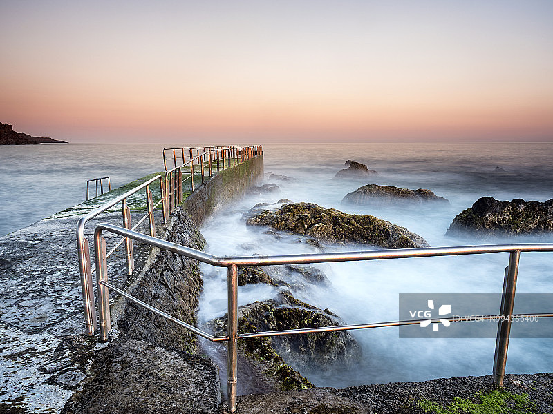 日落在岩石熔岩海岸附近的大西洋，Cinco Ribeiras, Terceira岛，亚速尔群岛，葡萄牙图片素材