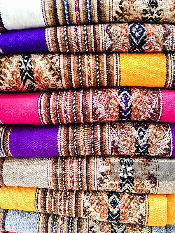 色彩斑斓的秘鲁编织纺织品与传统图案在南美市场。图片素材