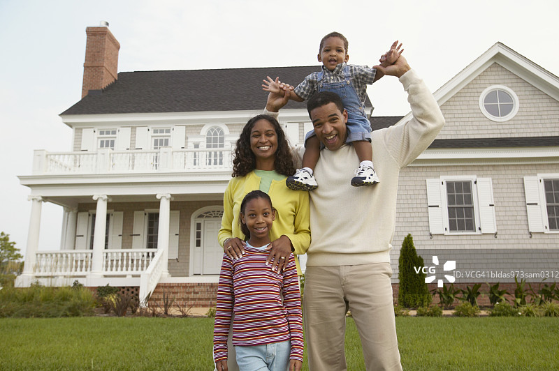 一对年轻夫妇和他们的孩子站在房子前面图片素材