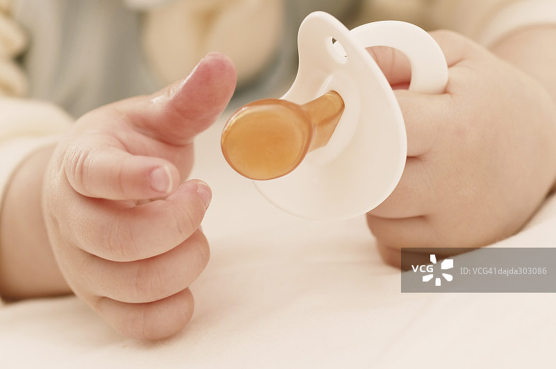 一个女婴的手和一个出牙戒指图片素材