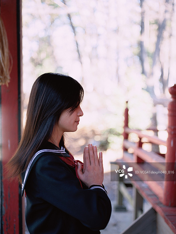 女孩在神龛外祈祷图片素材