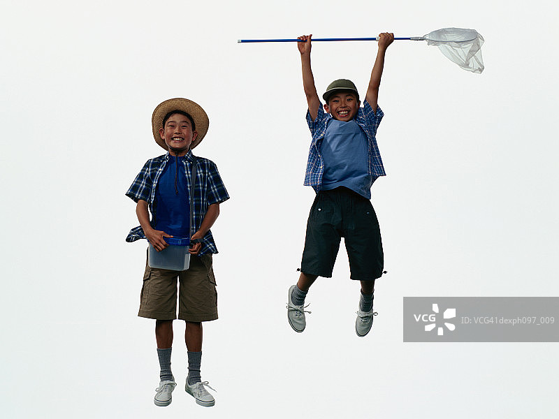 两个穿着露营服的亚洲小男孩，在半空中跳起来图片素材