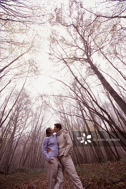 一对情侣站在森林里接吻图片素材
