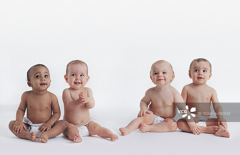 四个婴儿坐在尿布里的肖像图片素材