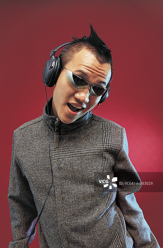 一个男人用耳机听音乐和唱歌的肖像图片素材
