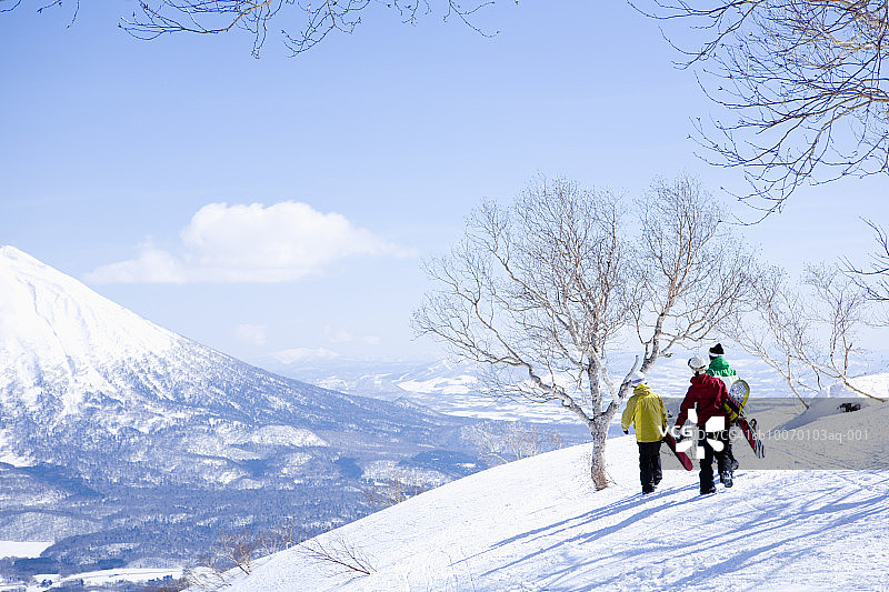 三个滑雪者在斜坡上行走，后视镜图片素材