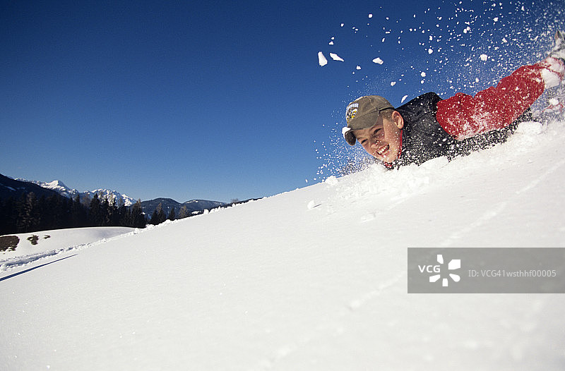 男孩滑下雪坡图片素材