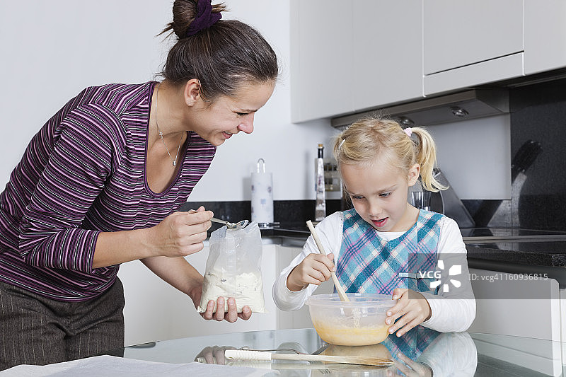 快乐的母亲和女儿一起在厨房烘焙图片素材
