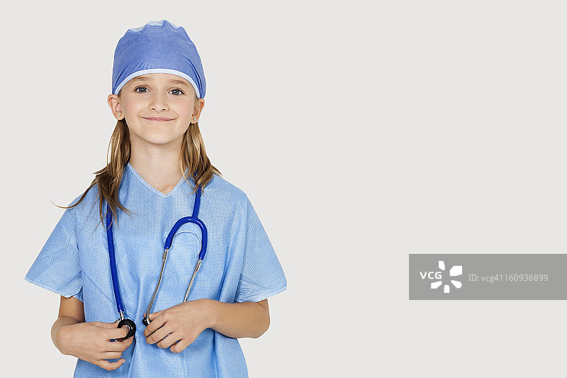 身着外科医生服装的年轻女孩的肖像，映衬着灰色背景图片素材