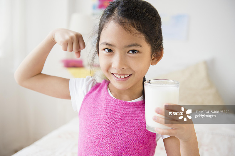 越南女孩边喝牛奶边秀肌肉图片素材