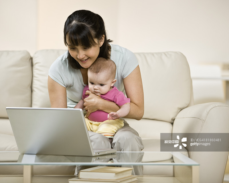 亚洲母亲和婴儿看笔记本电脑图片素材