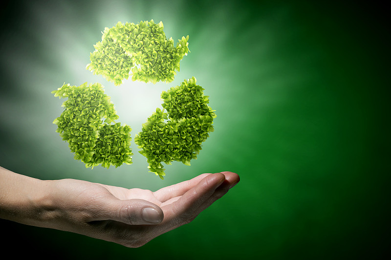 回收的概念。手握绿色回收标志的特写图片下载