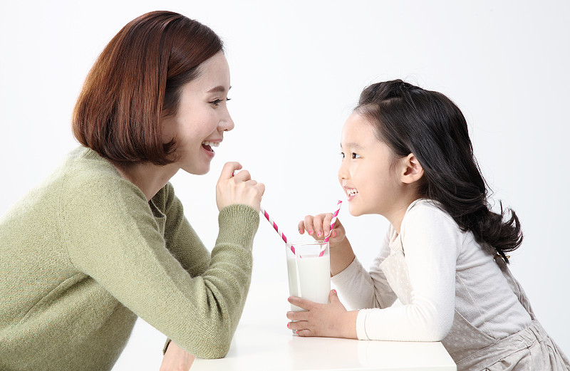 母亲和女儿喝着牛奶图片下载
