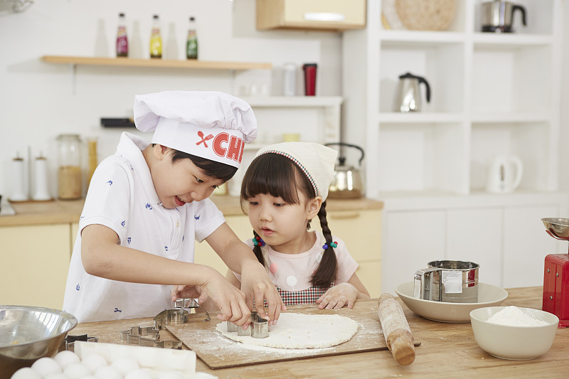 男孩和女孩在家厨房烘焙的照片摄影图片下载