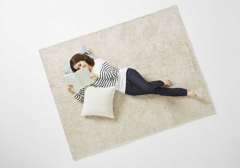 女人躺在地毯上看书的照片摄影图片下载