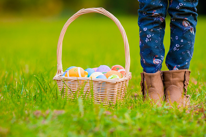 近距离观察草地上篮子里五颜六色的复活节彩蛋图片下载