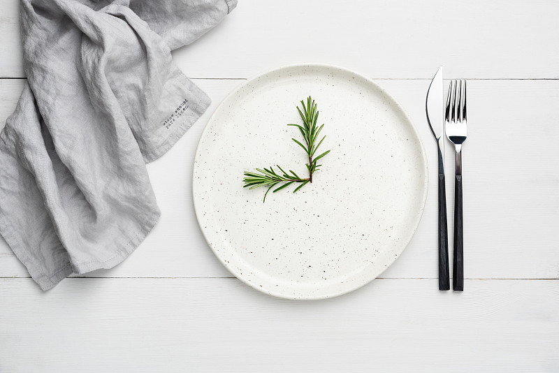 白色的盘子和餐具放在白色的木板上，食物背景图片下载