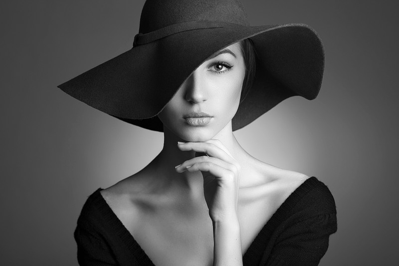 年轻漂亮的女人戴着黑帽子图片下载