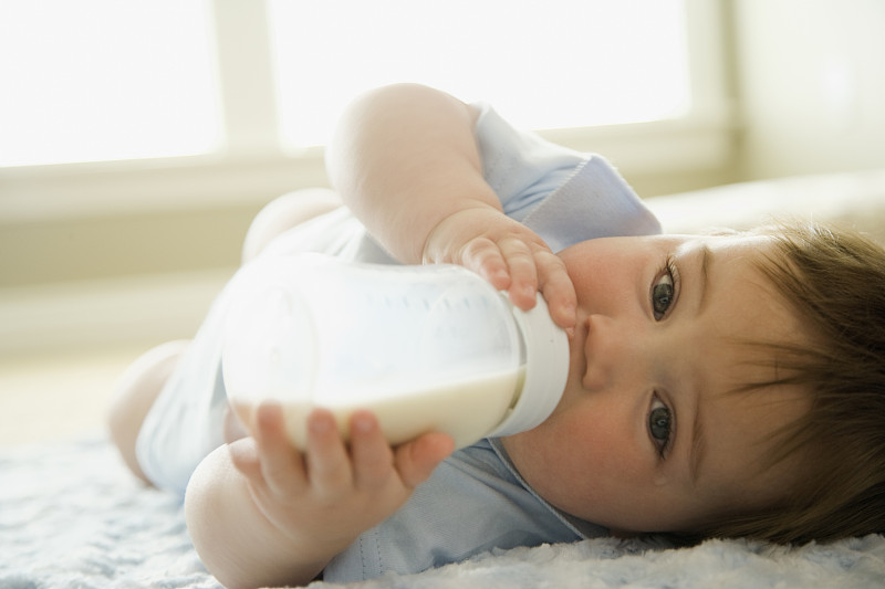 小男孩喝着奶瓶里的牛奶图片素材