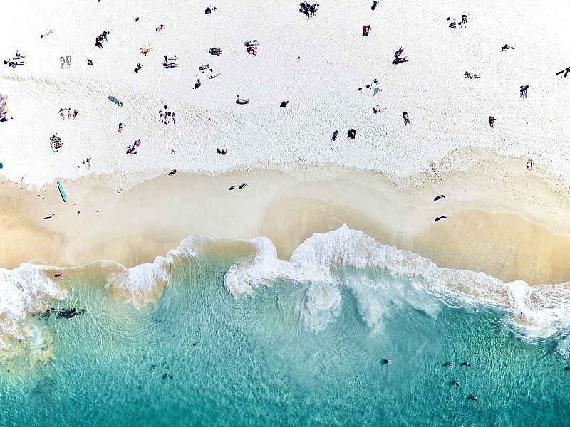 从空中拍摄的人们坐在海滩上的照片摄影图片下载