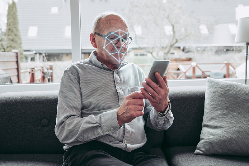 智能手机上的人脸识别软件对老年人进行面部扫描图片素材