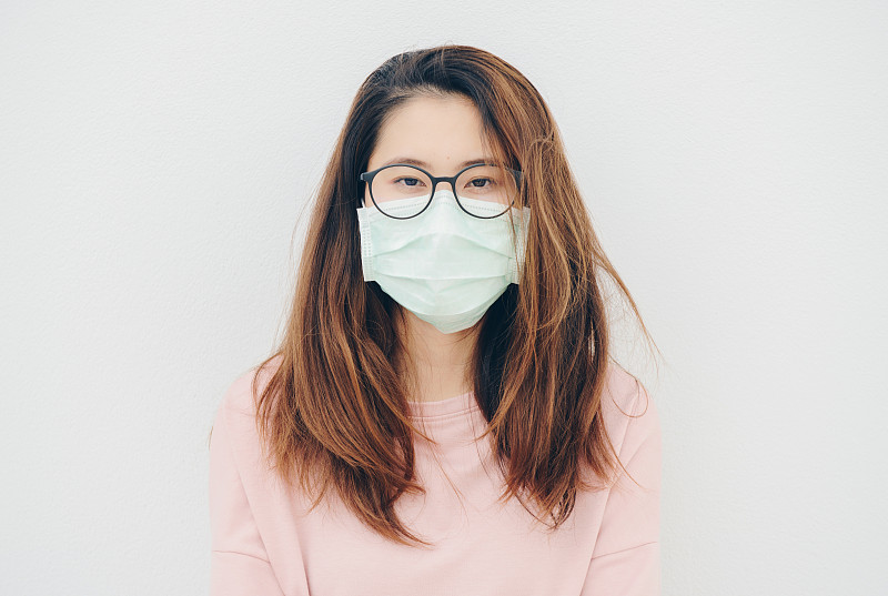 生病的亚洲妇女戴着面具以防止传染病和流感的肖像。图片素材