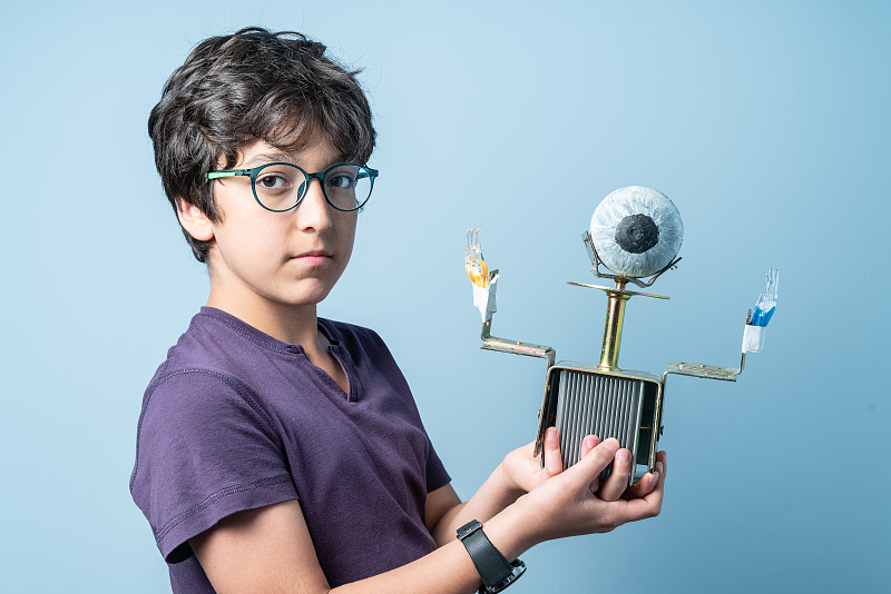 少年学校男孩的肖像展示他的机器人图片素材