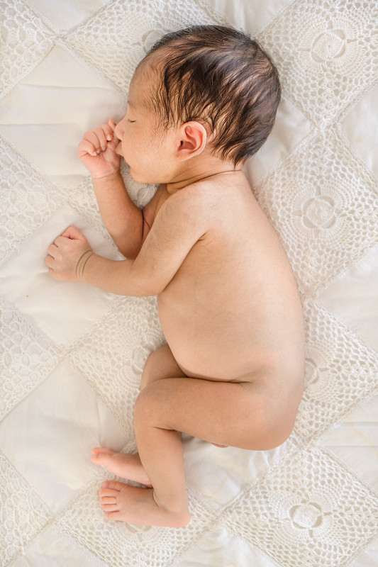 上图是赤裸的男婴在床上睡觉图片素材