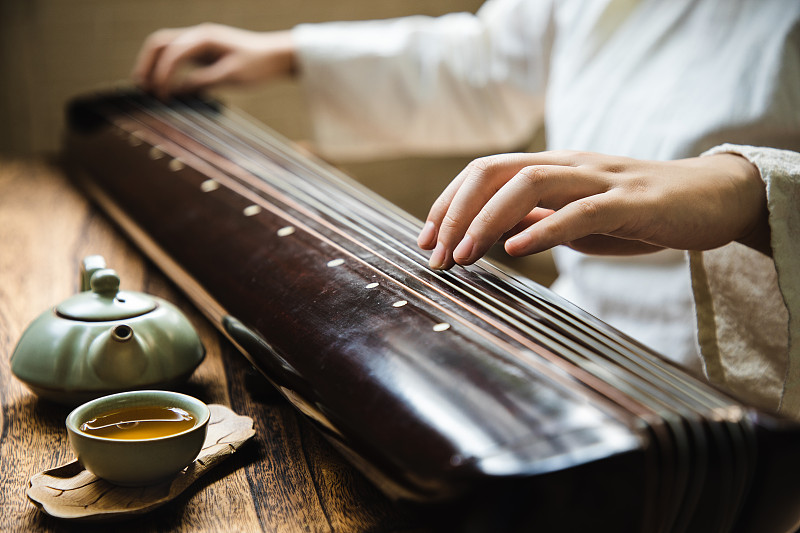 弹奏古琴(一种中国古代弦乐器)的亚洲妇女图片下载