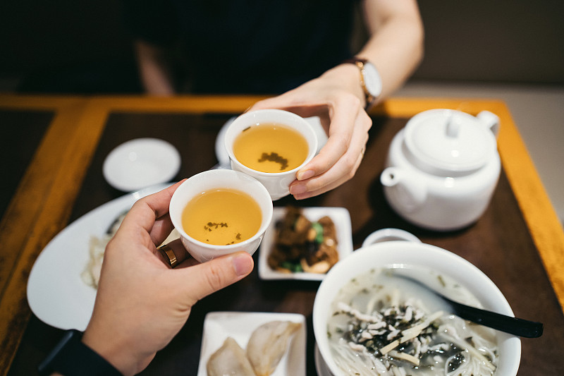 在中国餐馆用餐时，男女握手敬茶图片下载