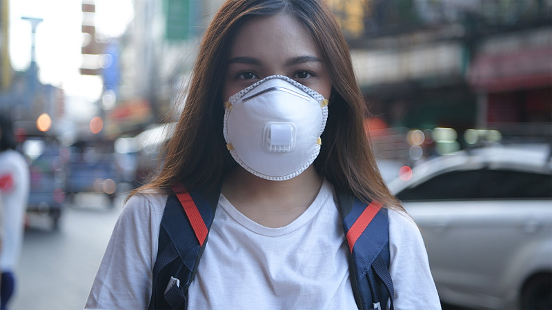 在城市里戴着防护面具的年轻女子图片素材