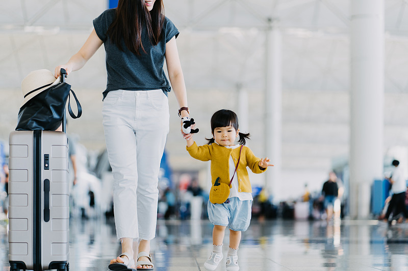快乐的年轻亚洲母亲与可爱的小女儿乘飞机度假，而走过机场大厅图片下载
