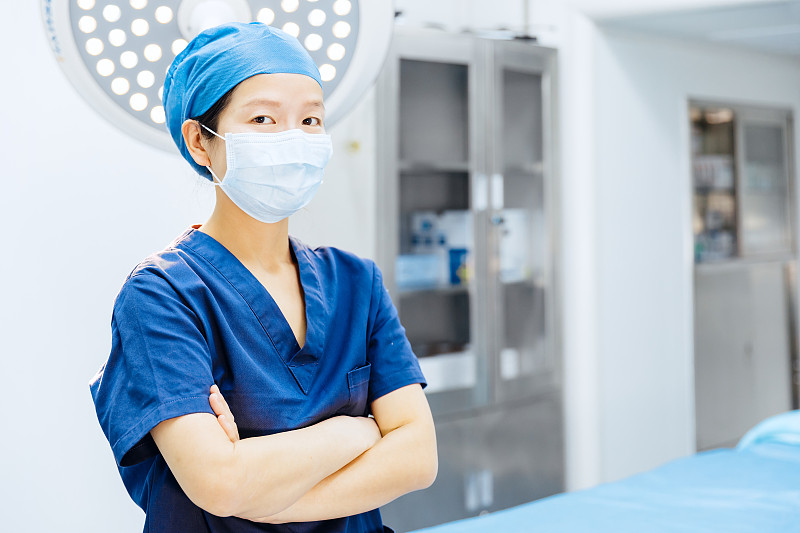 亚洲年轻女外科医生戴着外科口罩在手术室里图片下载