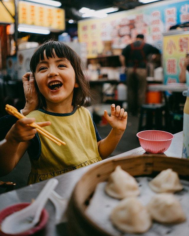 可爱的小女孩在台湾夜市享受晚餐时间图片下载