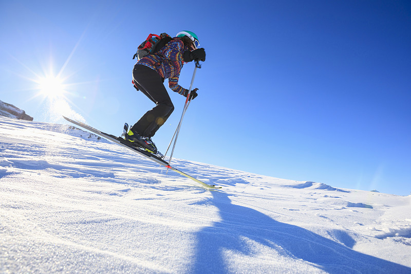 女子滑雪滑雪在阳光明媚的滑雪胜地滑雪业余冬季运动。高山雪景。意大利阿尔卑斯山脉的白云石圣母迪坎皮里奥，意大利。图片下载