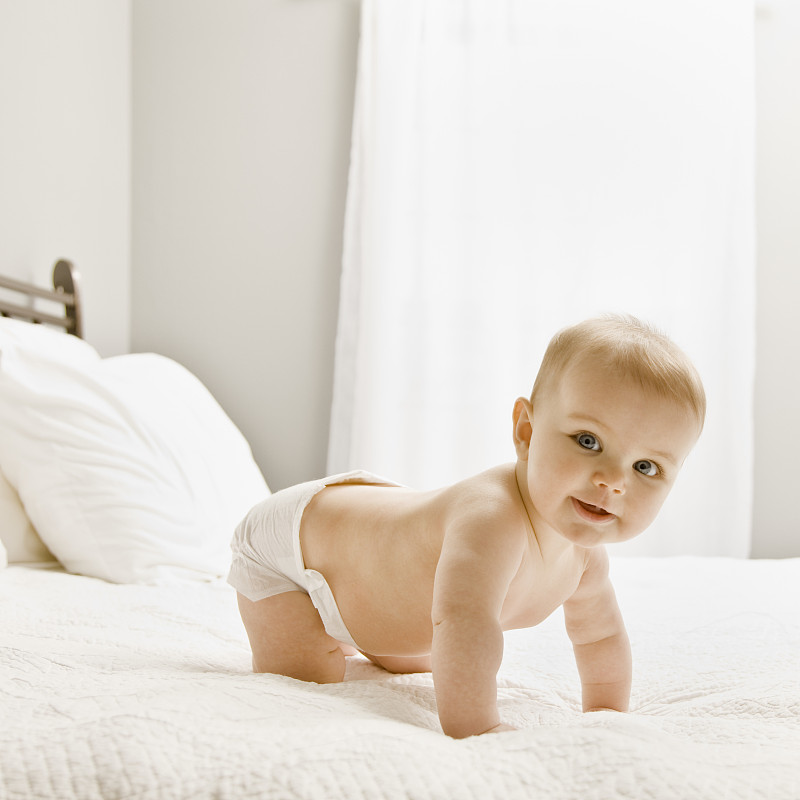 女婴(8个月)在床上爬行，肖像图片下载