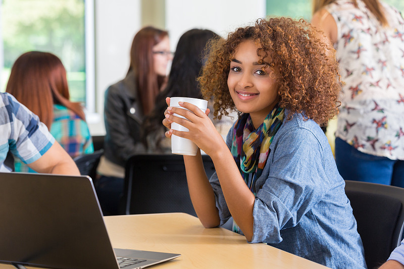 漂亮的非裔美国大学生一边学习一边喝咖啡图片下载