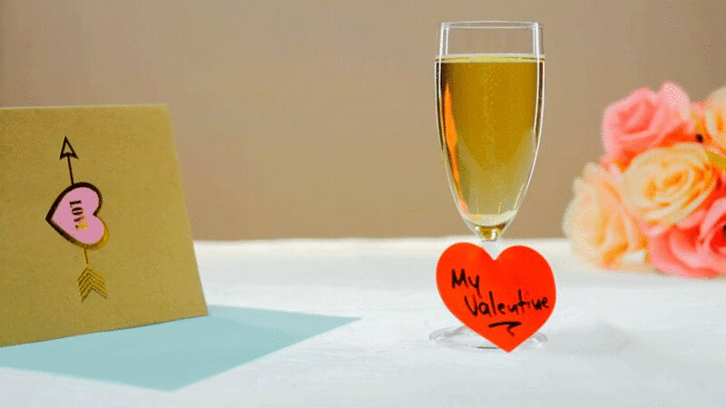 桌上放有情人节祝福、卡片和鲜花的香槟杯图片下载