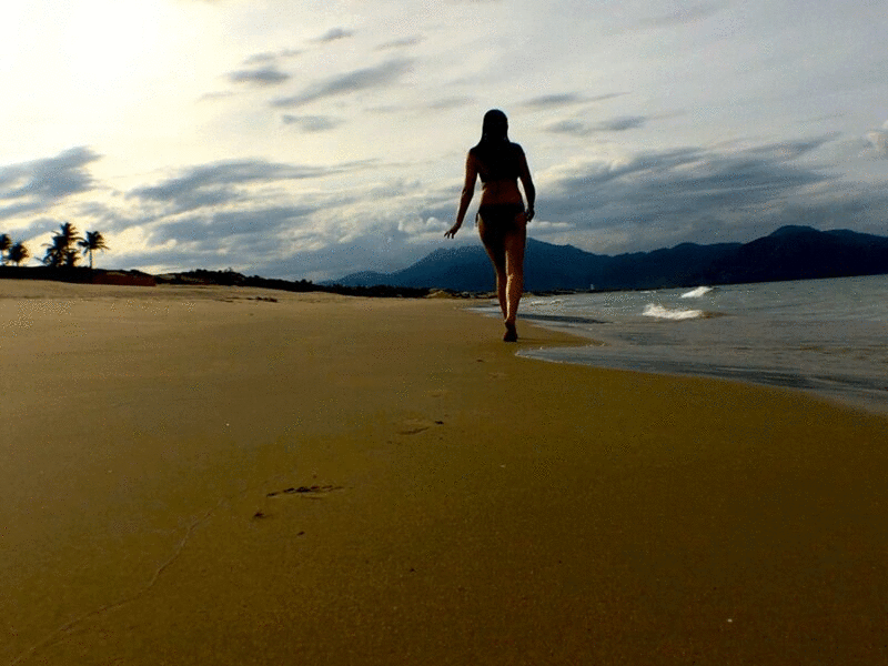 后视图的女人走在海滩上图片下载