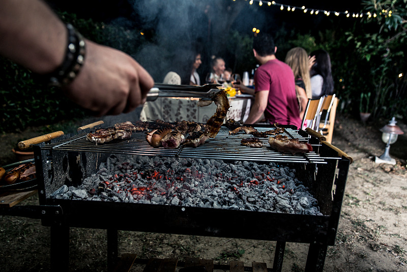 晚餐时间，一群朋友在后院烧烤图片素材